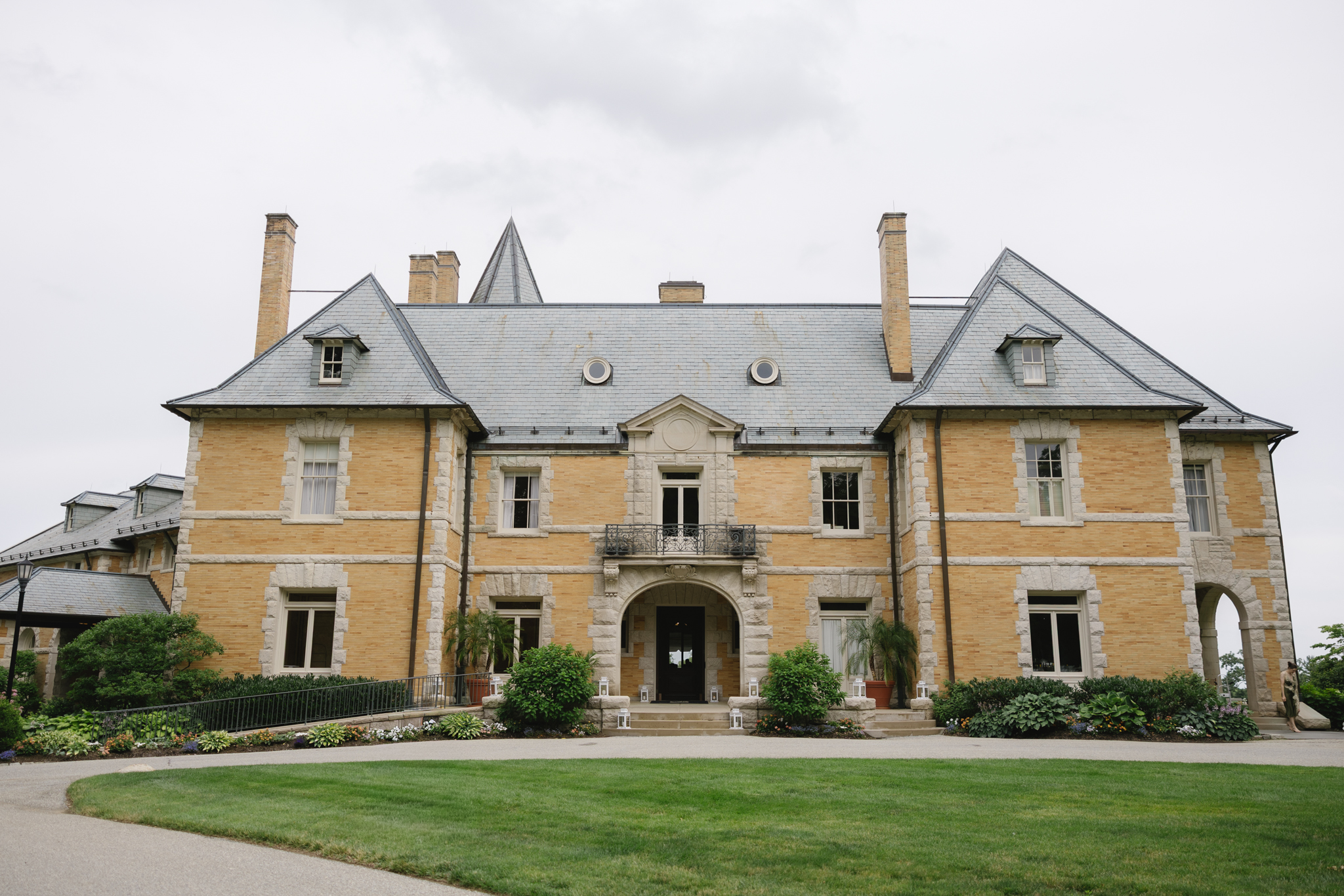 Newly-married-couple-celebrating-outside-the-historic-Cairnwood-Estate-with-classic-Pennsylvania-architecture