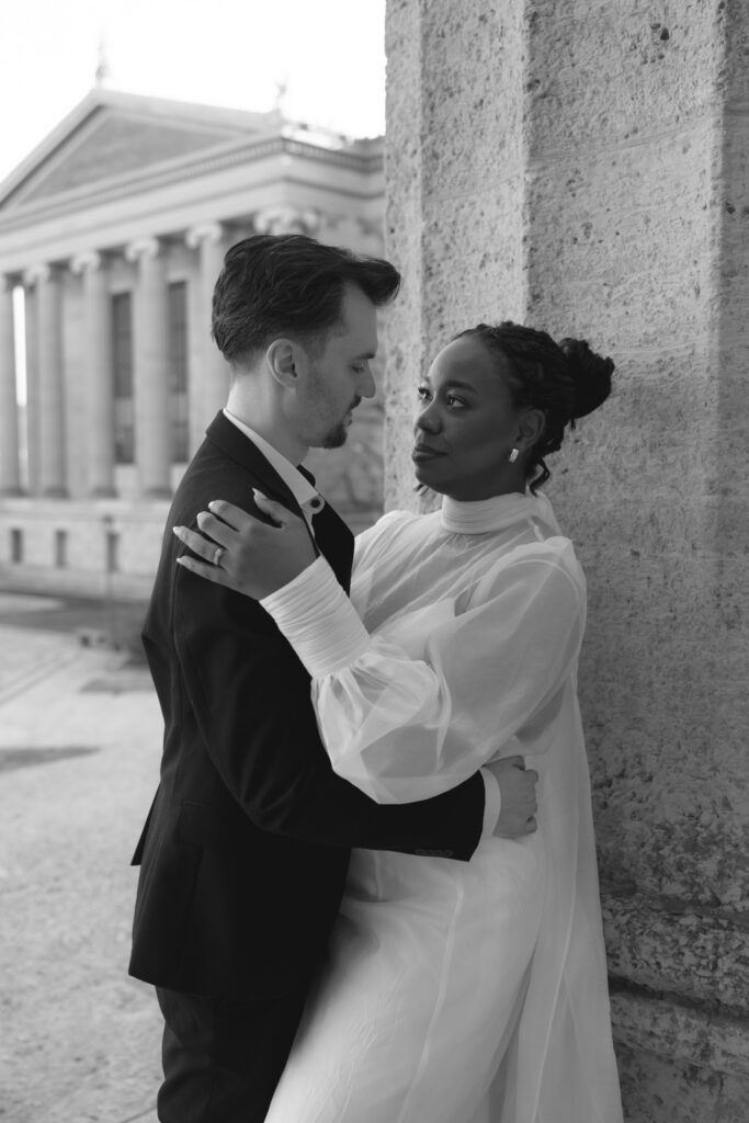 Bride-and-groom-sharing-a-quiet-moment-at-the-Philadelphia-Museum-of-Art-capturing-romantic-wedding-portraits-with-iconic-columns-and-soft-natural-light