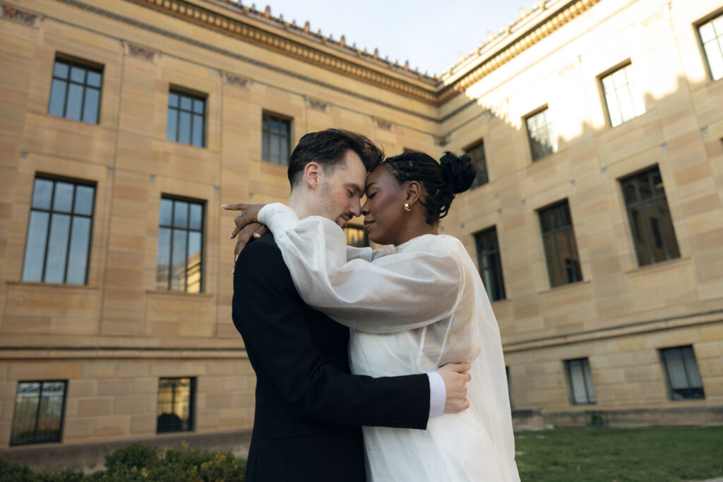 Bride-and-groom-sharing-a-quiet-moment-at-the-Philadelphia-Museum-of-Art-capturing-romantic-wedding-portraits-with-iconic-columns-and-soft-natural-light