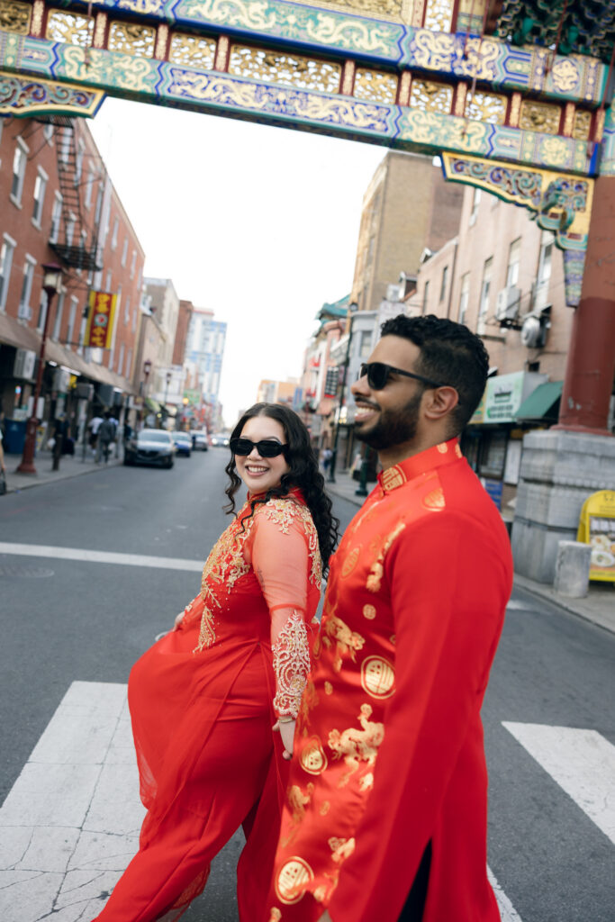 Couple-laughing-together-during-an-engagement-session-in-Philadelphia-Chinatown-with-city-lights-and-historic-architecture