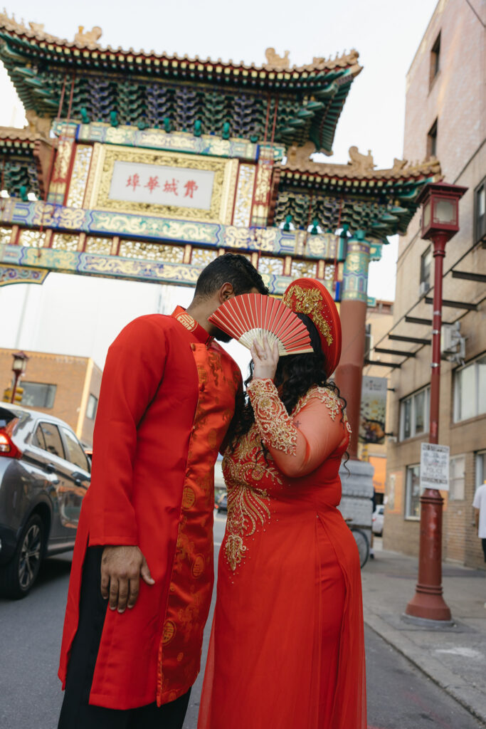 Couple-laughing-together-during-an-engagement-session-in-Philadelphia-Chinatown-with-city-lights-and-historic-architecture
