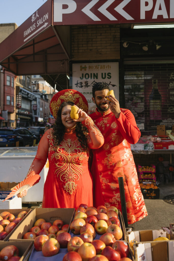 Couple-laughing-together-during-an-engagement-session-in-Philadelphia-Chinatown-with-city-lights-and-historic-architecture