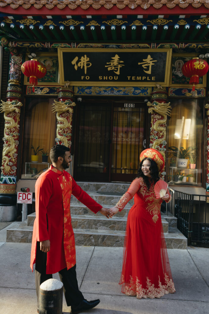 Couple-laughing-together-during-an-engagement-session-in-Philadelphia-Chinatown-with-city-lights-and-historic-architecture