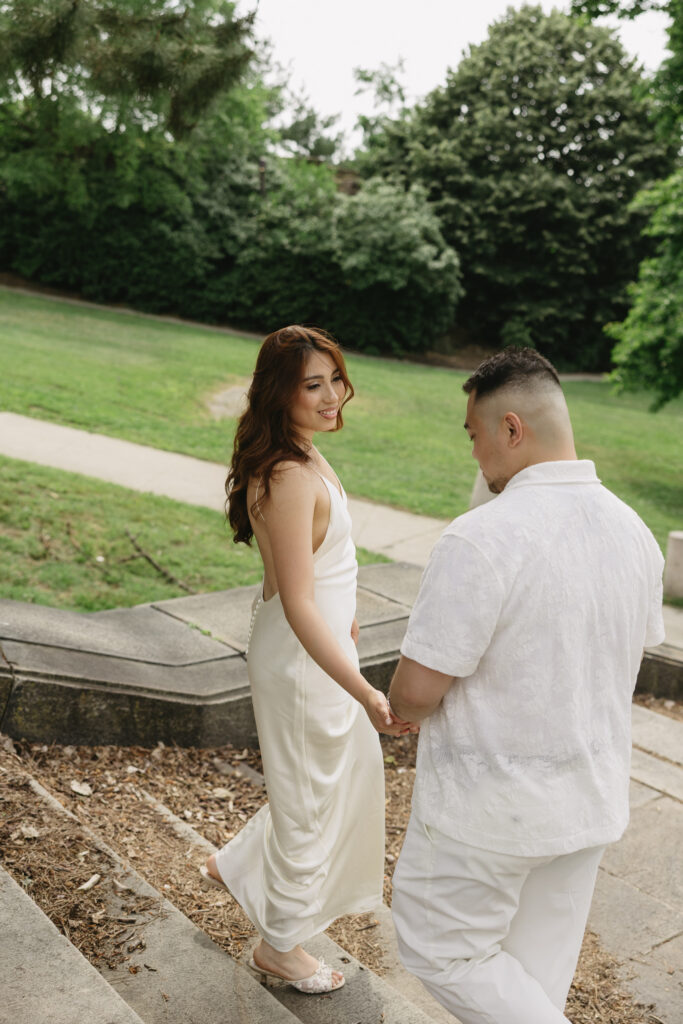 Elegant-couple-embracing-during-their-engagement-session-at-Fairmount-Water-Works-in-Philadelphia-with-the-Schuylkill-River-and-historic-architecture-in-the-background