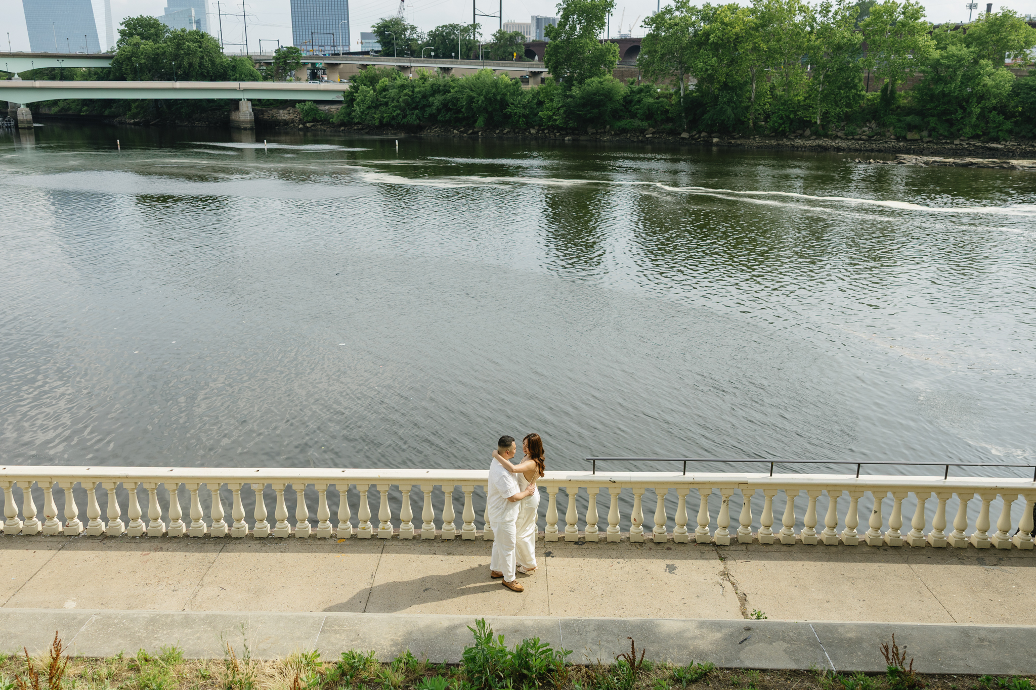 Elegant-couple-embracing-during-their-engagement-session-at-Fairmount-Water-Works-in-Philadelphia-with-the-Schuylkill-River-and-historic-architecture-in-the-background